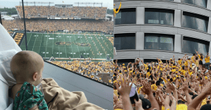 70,000 FANS PAUSE A FOOTBALL GAME TO WAVE AT A HOSPITAL FULL OF KIDS THAT OVERLOOKS THE STADIUM.